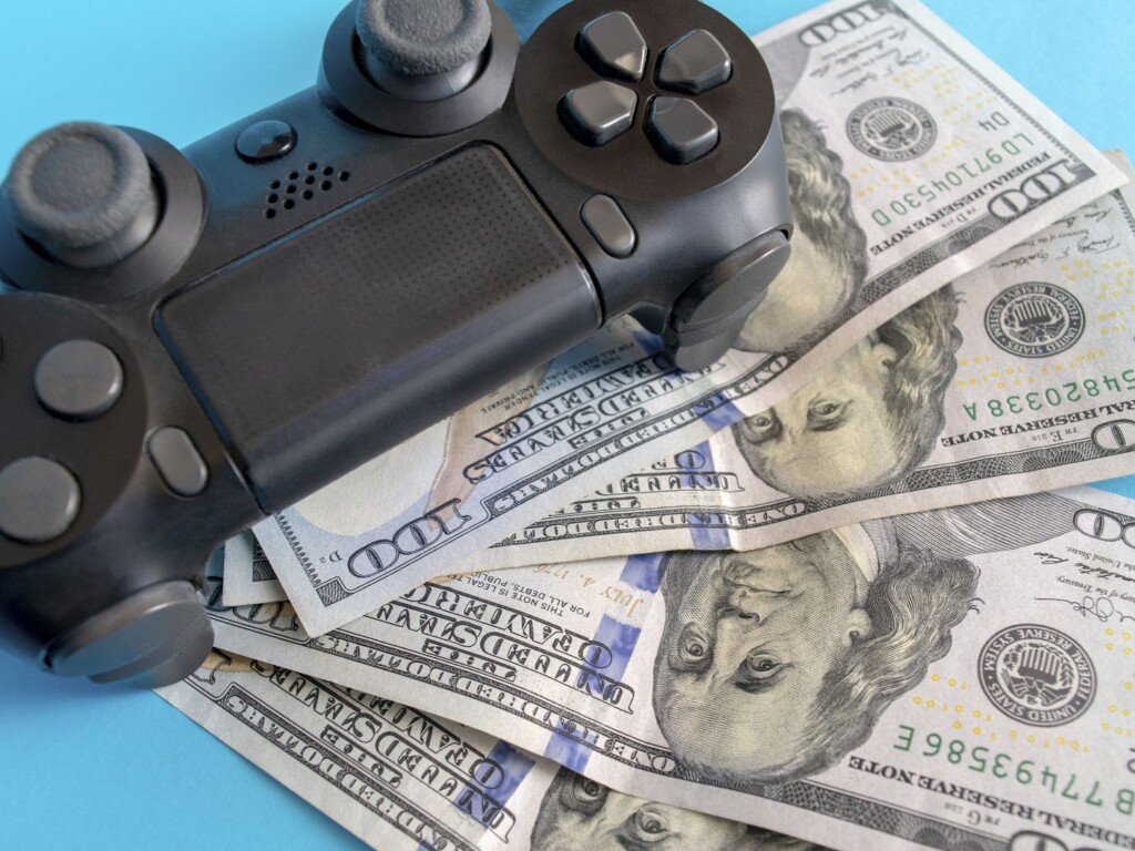 Un controlador de juego clásico rodeado de monedas.